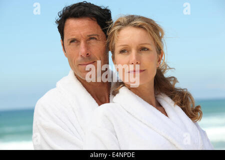 Couple sur la plage de white dressing downs Banque D'Images