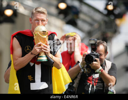 Berlin, Allemagne. 15 juillet, 2014. Bastian Schweinsteiger l'Allemagne (L) embrasse le trophée de la Coupe du Monde sur scène lors de la réception de bienvenue de l'équipe nationale de soccer devant la porte de Brandebourg, Berlin, Allemagne, 15 juillet 2014. L'équipe allemande a remporté le Brésil 2014 finale de la Coupe du Monde de soccer de la FIFA contre l'Argentine par 1-0 le 13 juillet 2014, remportant le titre de Coupe du monde pour la quatrième fois après 1954, 1974 et 1990. Photo : Michael Kappeler/dpa/Alamy Live News Banque D'Images