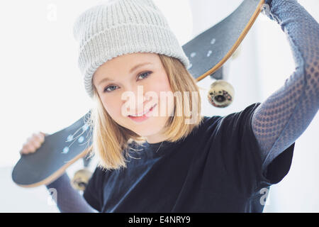 Portrait of young woman holding skateboard Banque D'Images