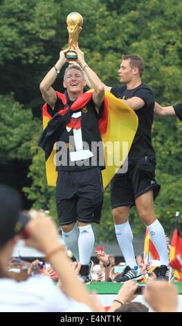 Bastian Schweinsteiger l'Allemagne (L) et Manuel Neuer soulever le trophée de la Coupe du Monde dans leurs mains et encouragements au cours de la réception de bienvenue de l'équipe nationale de soccer devant la porte de Brandebourg, Berlin, Allemagne, 15 juillet 2014. L'équipe allemande a remporté le Brésil 2014 finale de la Coupe du Monde de soccer de la FIFA contre l'Argentine par 1-0 le 13 juillet 2014, remportant le titre de Coupe du monde pour la quatrième fois après 1954, 1974 et 1990. Photo : Jens Wolf/dpa/Alamy Live News Banque D'Images