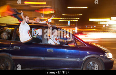 Wiesbaden, Allemagne. 14 juillet, 2014. L'Allemagne remporte la Coupe du Monde de la FIFA 2014. Les gens dans leur voiture et dans la rue acclamations et célébrer dans le centre-ville de Wiesbaden Allemagne après la victoire sur l'Argentine dans le match final. Motion voiture floue et city lights Crédit : Oliver Kessler/Alamy Live News Banque D'Images