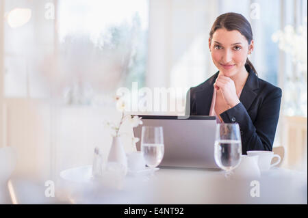 Businesswoman working on laptop in restaurant Banque D'Images