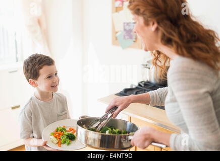 Mère et fils (6-7) servant le dîner sain Banque D'Images