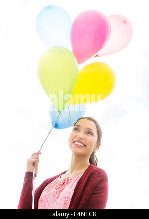 Jeune femme avec des ballons colorés Banque D'Images