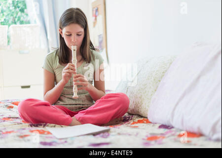 Girl (10-11) playing flute Banque D'Images
