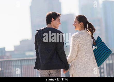 Jeune couple en train de marcher, bâtiments en arrière-plan Banque D'Images