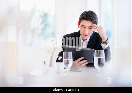 Portrait of business man using digital tablet in restaurant Banque D'Images