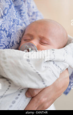 Close up of Baby Boy (2-5 months) sleeping in mother's arms Banque D'Images