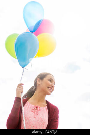 Jeune femme avec des ballons colorés Banque D'Images