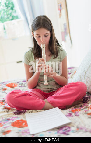 Girl (10-11) playing flute Banque D'Images