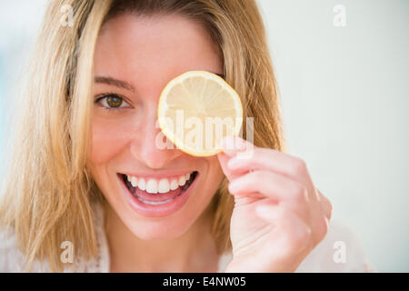 Portrait of young woman holding tranche de citron Banque D'Images