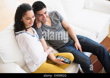 Jeune couple watching tv on sofa Banque D'Images