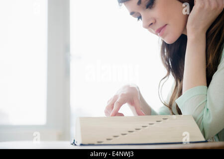 Young woman reading dictionary Banque D'Images
