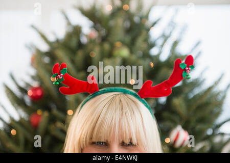 Blonde woman wearing reindeer headband Banque D'Images