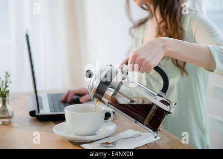 Young woman pouring coffee en tasse Banque D'Images