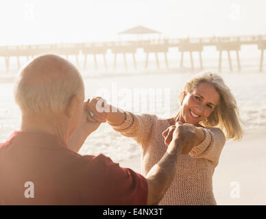 USA, Floride, Jupiter, Senior couple dancing on beach Banque D'Images