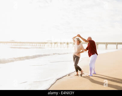 USA, Floride, Jupiter, Senior couple dancing on beach Banque D'Images