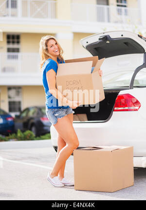 USA, Floride, Jupiter, young woman carrying box de voiture dans sa nouvelle maison Banque D'Images