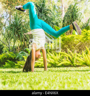 Girl (8-9) faisant la roue sur cour Banque D'Images