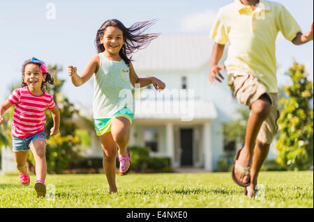 USA, Floride, Jupiter, les filles (4-5, 8-9) et garçon (6-7) jouant sur la cour avant Banque D'Images