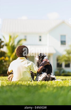 USA, Floride, Jupiter, vue arrière de boy (6-7) sitting with dog Banque D'Images