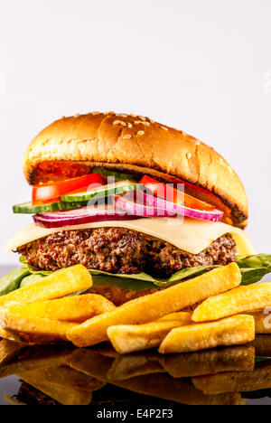 Hamburger frais avec légumes et frites sur fond reflètent Banque D'Images