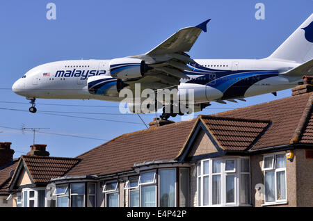 L'approche de la piste d'Heathrow par Airbus A380 de Malaysia Airlines avion à basse altitude au-dessus des toits des maisons et sur l'approche pour l'atterrissage de l'aéroport Heathrow de Londres, Myrtle Avenue, UK. Banque D'Images