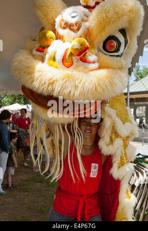 Woman putting on costume Lion Chinois au festival - USA Banque D'Images