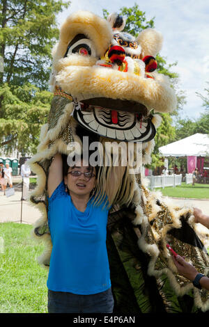 Woman putting on costume Lion Chinois au festival - USA Banque D'Images