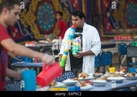 Le Caire, Égypte. 15 juillet, 2014. Un homme prépare des repas pour un banquet de bienfaisance au Caire, Égypte, le 15 juillet 2014. La charité des banquets, ou ma'idat al-Rahman, représentent une longue tradition du Ramadan en Egypte, par lequel riches patrons fournissent leurs moins riches coreligionnaires avec les repas pour rompre le jeûne. © Cui Xinyu/Xinhua/Alamy Live News Banque D'Images