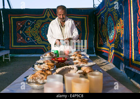 Le Caire, Égypte. 15 juillet, 2014. Un homme prépare des repas pour un banquet de bienfaisance au Caire, Égypte, le 15 juillet 2014. La charité des banquets, ou ma'idat al-Rahman, représentent une longue tradition du Ramadan en Egypte, par lequel riches patrons fournissent leurs moins riches coreligionnaires avec les repas pour rompre le jeûne. © Cui Xinyu/Xinhua/Alamy Live News Banque D'Images