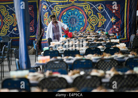 Le Caire, Égypte. 15 juillet, 2014. Un homme prépare des repas pour un banquet de bienfaisance au Caire, Égypte, le 15 juillet 2014. La charité des banquets, ou ma'idat al-Rahman, représentent une longue tradition du Ramadan en Egypte, par lequel riches patrons fournissent leurs moins riches coreligionnaires avec les repas pour rompre le jeûne. © Cui Xinyu/Xinhua/Alamy Live News Banque D'Images