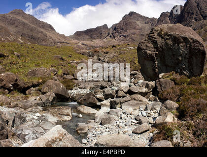 Rocky lit & énorme rocher avec la corrie de Coire Lagan dans les montagnes Cuillin noires au-delà, l'île de Skye, Écosse, Royaume-Uni Banque D'Images