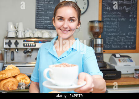 Serveuse dans Café servant du café avec la clientèle Banque D'Images