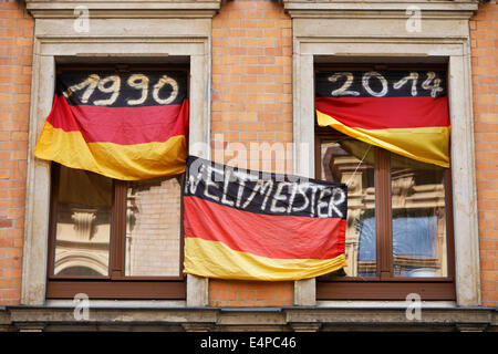 L'Allemagne Championne du Monde de Football 1954 1974 1990 et 2014 ; avec des drapeaux de l'année dates au fenêtres d'une fan allemande Banque D'Images