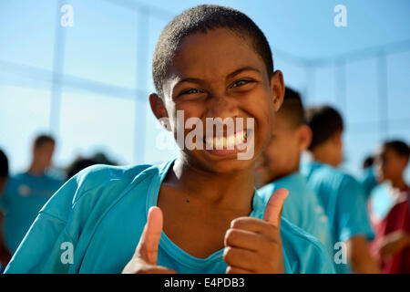 Boy making thumbs-up geste, Guararape favela, Rio de Janeiro, Brésil Banque D'Images