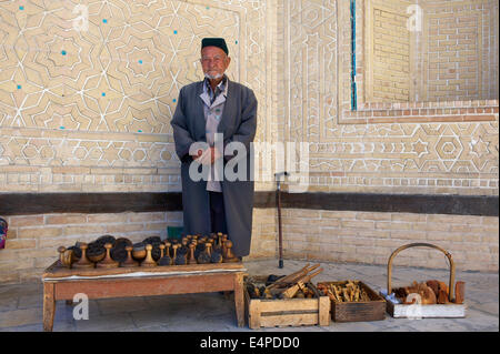 L'homme local avec le pain des timbres en face de la mosquée Kalon, Boukhara, Ouzbékistan Banque D'Images