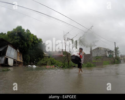 La province de Cavite, Philippines. 16 juillet, 2014. Un homme patauge dans les portées par le typhon Rammasun dans la province de Cavite, Philippines, le 16 juillet 2014. Au moins 5 personnes ont été tuées à la suite de l'assaut du typhon Rammasun (nom local : Glenda) qui a paralysé la capitale des Philippines, de Manille, mercredi. Credit : Rouelle Umali/Xinhua/Alamy Live News Banque D'Images