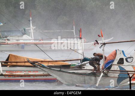 La province de Cavite, Philippines. 16 juillet, 2014. Les pêcheurs essayer de s'assurer de leur bateau qu'ils bravent les vents forts de typhon Rammasun dans la province de Cavite, Philippines, le 16 juillet 2014. Au moins 5 personnes ont été tuées à la suite de l'assaut du typhon Rammasun (nom local : Glenda) qui a paralysé la capitale des Philippines, de Manille, mercredi. Credit : Rouelle Umali/Xinhua/Alamy Live News Banque D'Images