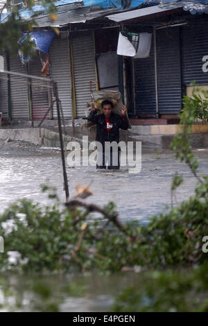 La province de Cavite, Philippines. 16 juillet, 2014. Un homme patauge dans les portées par le typhon Rammasun dans la province de Cavite, Philippines, le 16 juillet 2014. Au moins 5 personnes ont été tuées à la suite de l'assaut du typhon Rammasun (nom local : Glenda) qui a paralysé la capitale des Philippines, de Manille, mercredi. Credit : Rouelle Umali/Xinhua/Alamy Live News Banque D'Images