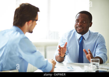 Image de deux jeunes hommes d'interaction at meeting in office Banque D'Images