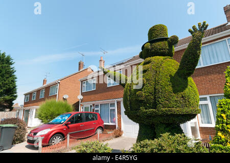 D'un grand travail topiaire gros homme dans un chapeau dans le jardin de devant d'une maison à Broadstairs. Banque D'Images