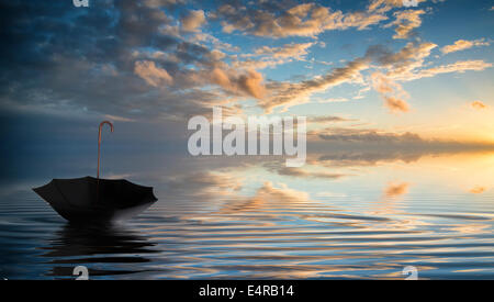 Parapluie à l'envers sur le flottant d'hiver Magnifique Ciel de coucher du soleil reflétée dans les vagues Banque D'Images