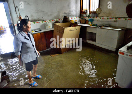 Yuqing, province du Guizhou en Chine. 16 juillet, 2014. Une dame vues sa maison inondée à Zhengfu Township, comté de Yuqing, sud-ouest de la Chine dans la province du Guizhou, le 16 juillet 2014. De fortes pluies a frappé l'ensemble du pays au cours des derniers jours. De loin, aucune victime n'a été signalée. Crédit : Il Chunyu/Xinhua/Alamy Live News Banque D'Images