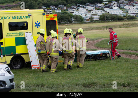 Aberystwyth, Pays de Galles, Royaume-Uni. 16 juillet, 2014. Un homme de 38 ans a été pris au piège comme il l'arbres abattus sur une petite colline boisée dans Clarach, Aberystwyth aujourd'hui. L'arbre est posé sur l'homme l'épinglage à terre pendant environ 5 minutes jusqu'à ce que ses collègues pourraient le libérer. Les équipes de sauvetage ont assisté à l'incendie avec l'ambulance, les ambulanciers et les services d'ambulance aériens. L'homme a été soigneusement réalisée à bord de l'ambulance par l'équipe d'incendie où ses blessures ont été évalués avant qu'il soit pris par la route à l'hôpital. Bronglais Crédit : Jon Freeman/Alamy Live News Banque D'Images