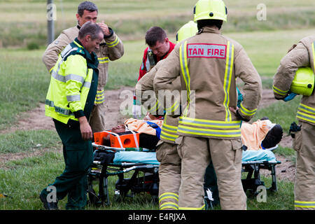 Aberystwyth, Pays de Galles, Royaume-Uni. 16 juillet, 2014. Un homme de 38 ans a été pris au piège comme il l'arbres abattus sur une petite colline boisée dans Clarach, Aberystwyth aujourd'hui. L'arbre est posé sur l'homme l'épinglage à terre pendant environ 5 minutes jusqu'à ce que ses collègues pourraient le libérer. Les équipes de sauvetage ont assisté à l'incendie avec l'ambulance, les ambulanciers et les services d'ambulance aériens. L'homme a été soigneusement réalisée à bord de l'ambulance par l'équipe d'incendie où ses blessures ont été évalués avant qu'il soit pris par la route à l'hôpital. Bronglais Crédit : Jon Freeman/Alamy Live News Banque D'Images