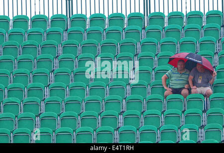 Royal Liverpool Golf Club, Hoylake, Angleterre. 16 juillet, 2014. La Finale ouverte jour de pratique. Les spectateurs à l'abri sous un parapluie lors de fortes pluies à la pratique. Credit : rsdphotography/Alamy Live News Banque D'Images