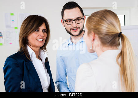 Close-up of young business woman rencontre avec deux jeunes gens d'affaires, en discussion, Allemagne Banque D'Images