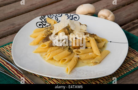 Pâtes aux champignons hachés et le parmesan sur le livre blanc de la plaque carrée