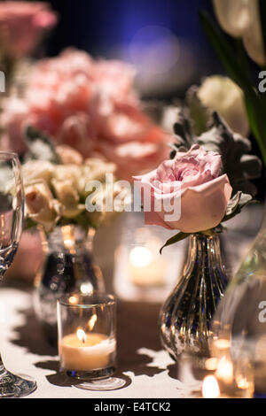 Close-up de vases de roses sur la table aux chandelles avec titulaire votive à la réception, Canada Banque D'Images